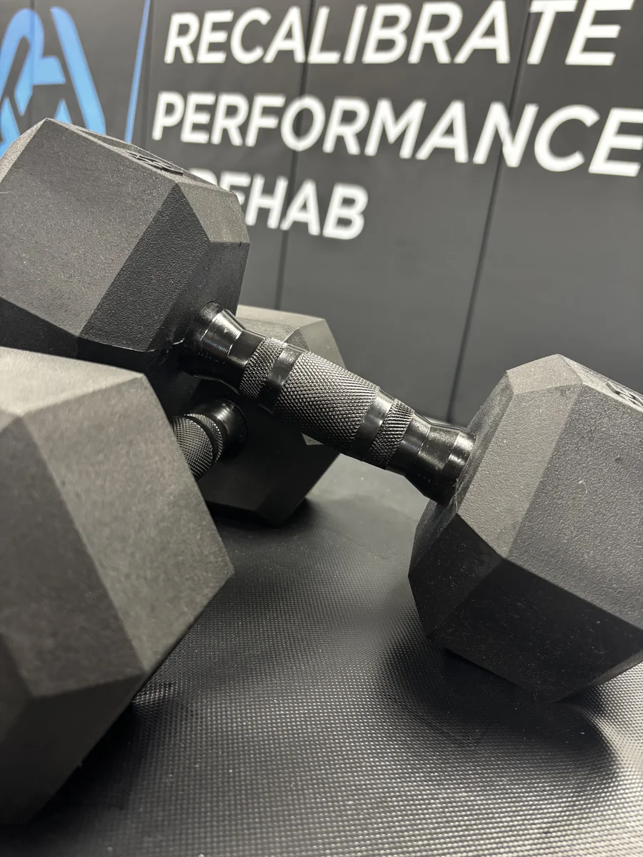 Hex dumbbells in the training area at Recalibrate Performance and Rehab in College Station, TX